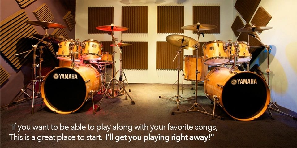 Drum instructor teaching a student at a kit